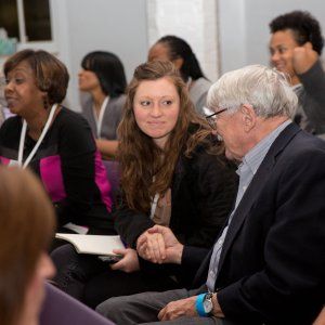 Attendees at a church-hosted event shaking hands and introducing themselves.