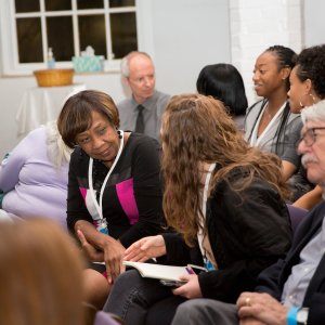 Woman extending her hand for a handshake upon meeting another attendee at a church-hosted event.