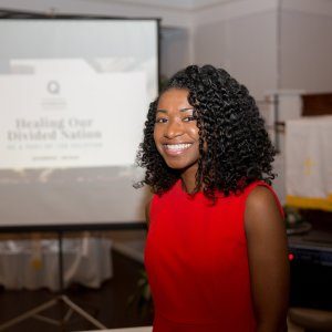 Our founder Kahlida smiling in front of a Powerpoint slideshow that's about to begin.