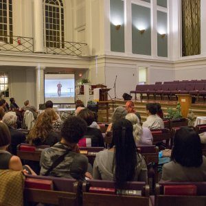 Reconcilers sitting in pews, watching a slideshow presentation about fighting racial injustice.