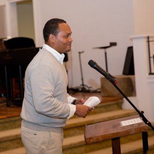 A social justice advocate approaching the microphone to begin his speech.