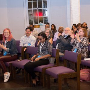 Attendees at a racial reconcilation event applauding after a speech.