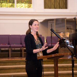 A racial justice advocate speaking at the podium during a church-hosted event in New Orleans.