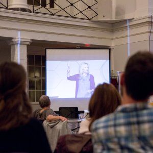 People watching a slideshow about racial divides at a church-hosted event.