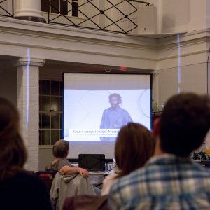 People watching a slideshow about racial justice at a church-hosted event.